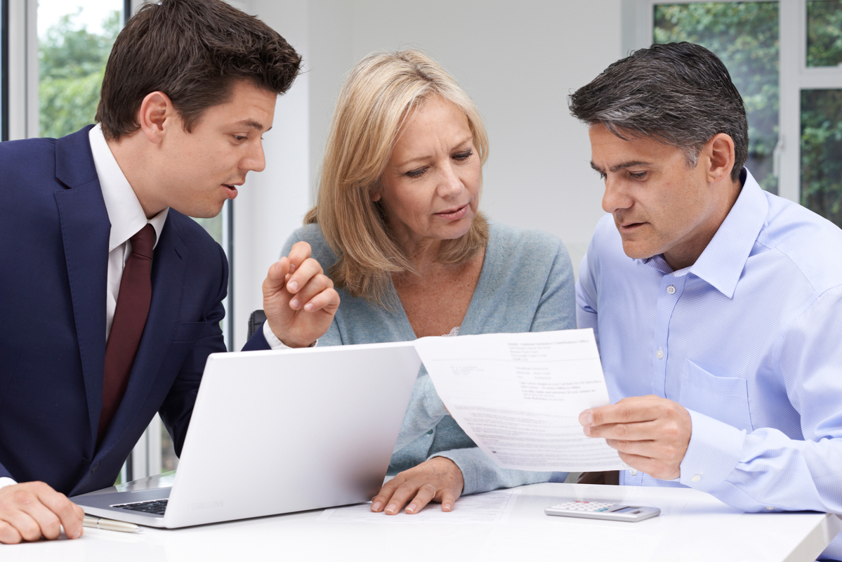 Three adults reviewing a document